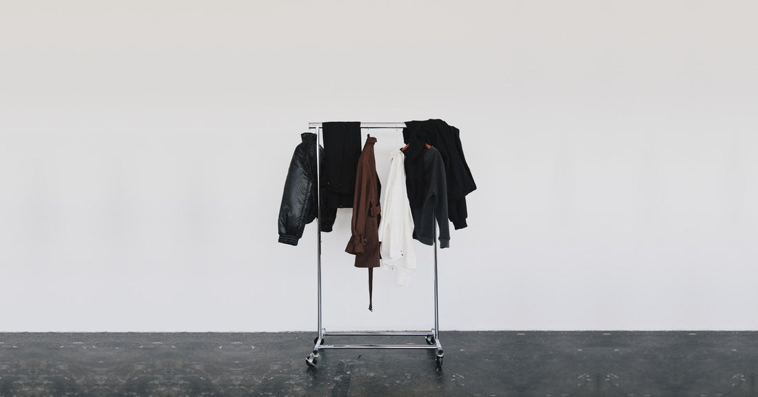 A rail of Stadion outerwear and tailoring in an empty white studio