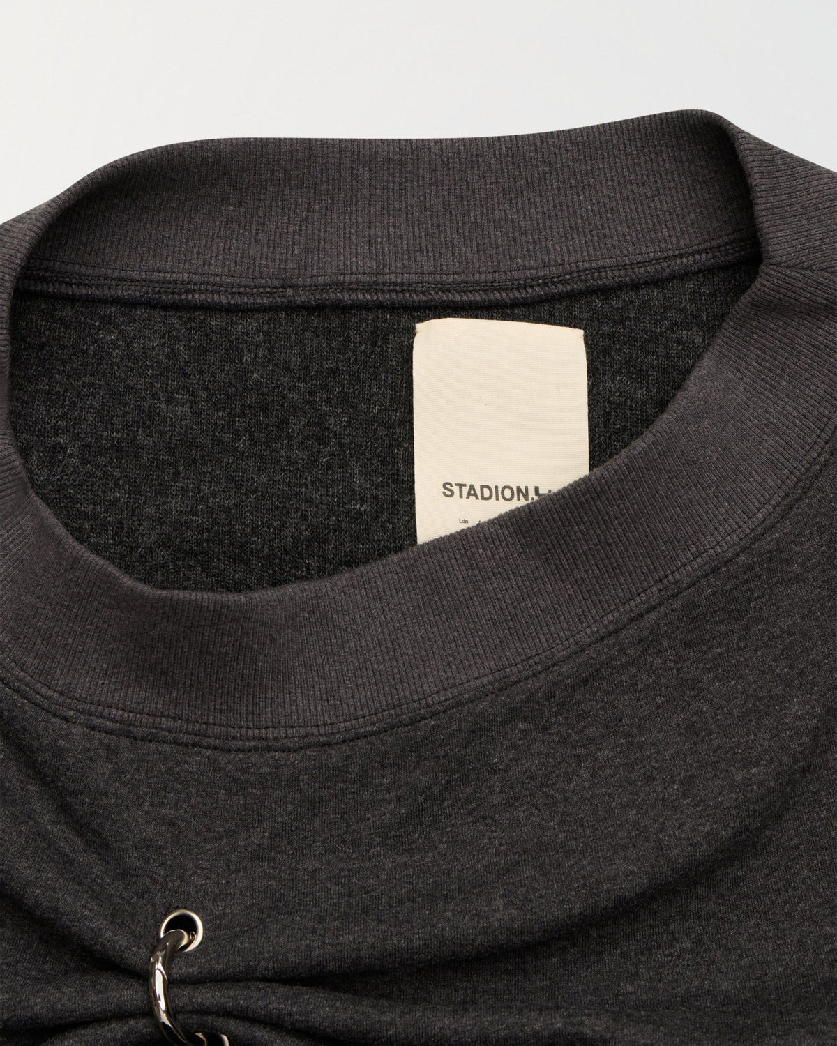 Detail of the neckline and woven Stadion label on the Grab sweater