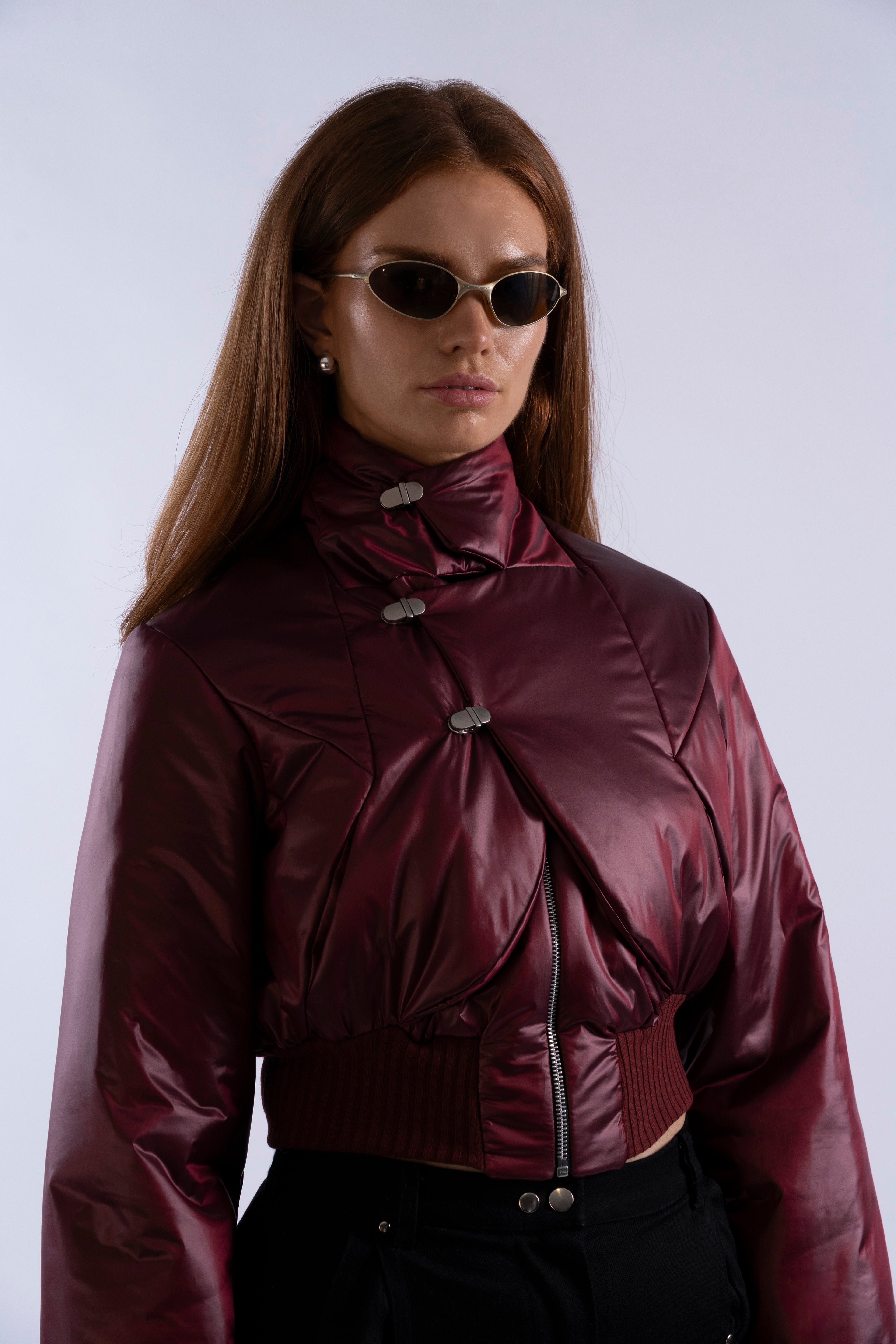 Angled view of Interface Bomber in Oxblood highlighting aluminium toggles and high collar.