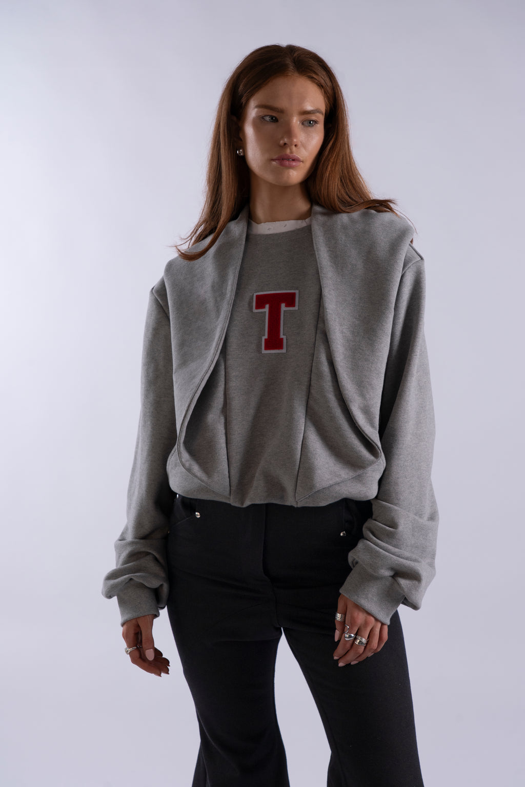 Model wearing grey STN Collegiate Hoodie by Stadion with red T logo, showing relaxed fit and minimal London streetwear design.