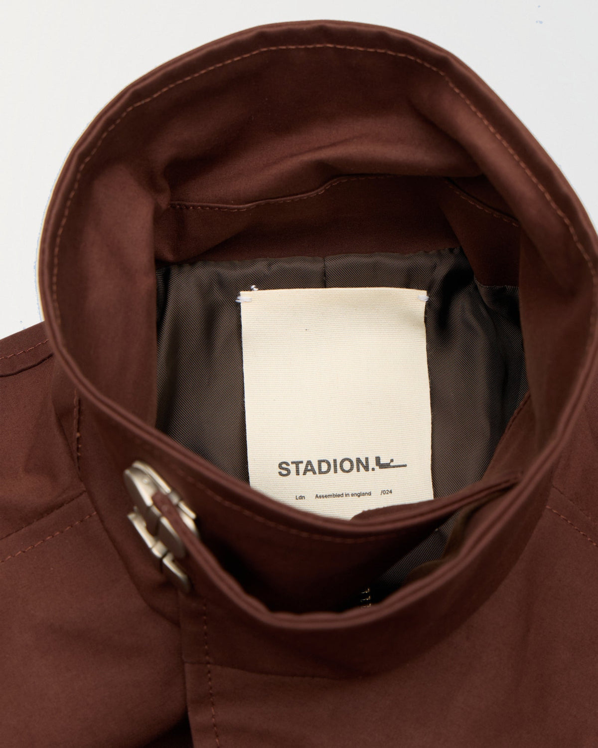 Detail of the funnel collar and woven Stadion label inside the Sylvia trench dress